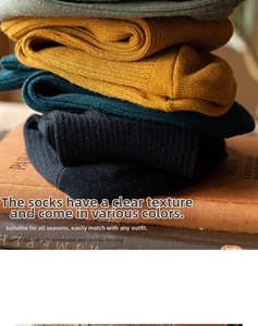 Close-up of colorful vertical ribbed knit cotton socks stacked with vintage books