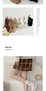 Close-up of knit cotton socks with bear embroidery and ruffle edges in earthy tones