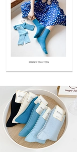 Detail of ribbed knit cotton mid-calf socks in various colors including blue and cream