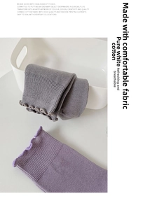 Detail of combed cotton socks with wavy edges in a minimalist white storage basket