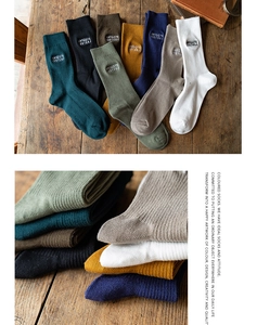 Close-up of ribbed cotton crew socks with vintage embroidery labels in various colors