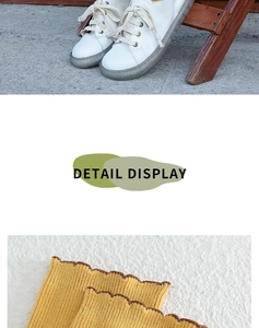 Detail of yellow ribbed knit socks with wavy edges paired with white casual shoes