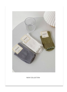 Detail showing combed cotton texture and delicate ruffle trim on three color mid-calf socks