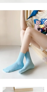 Detail of light blue ribbed cotton socks showing knit texture on a wooden step