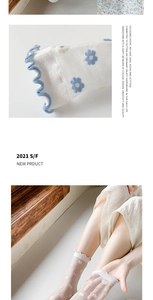 Detail of white mesh socks featuring blue flower embroidery and wavy ruffled cuffs