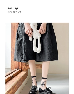 Detail of sheer white Lolita socks with bear print paired with black flat shoes