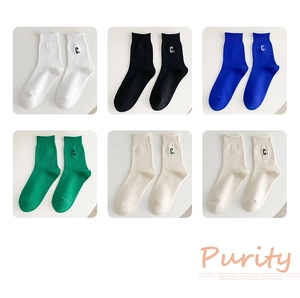 Close-up of ribbed cotton crew socks in six colors featuring embroidered C letter