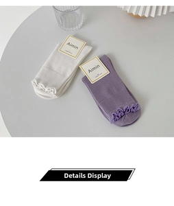 Detail of ruffled cuffs on combed cotton slouch socks in white and soft lavender purple