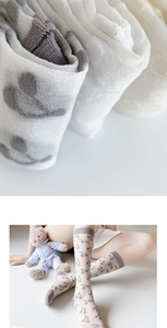 Macro detail of breathable knit fabric and grey music notes on kids' knee-high socks