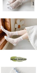 Detail of sheer mesh socks featuring 3D floral embroidery and ruffled elastic cuffs