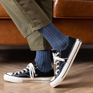 Men's breathable cotton rib crew socks in navy blue paired with classic black canvas shoes