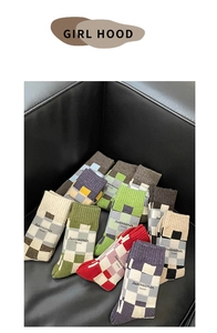 Flat lay of retro checkerboard wool socks in vibrant colors on a black leather surface