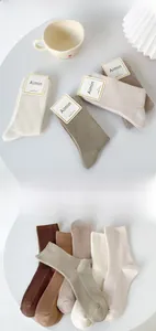 Macro detail of combed cotton ribbed socks in earthy tones with minimalist tags