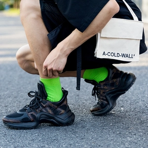 Black and brown monogram chunky sneakers with neon green mid-calf sports socks