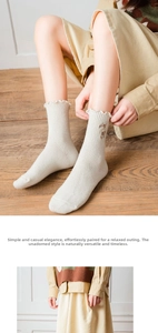 Detail of cream knit crew socks with ruffled cuffs and delicate floral embroidery