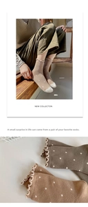 Close-up of vintage polka dot cotton socks featuring lettuce edge trim and cozy knit texture