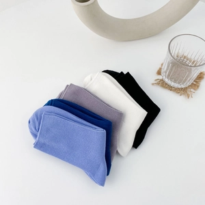 Five pairs of solid color ribbed cotton crew socks in pastel and neutral tones