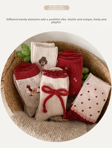 Detail of wool socks with 3D red bows and cute animal embroidery in a basket