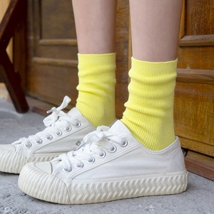 Chaussettes mi-hautes en coton jaune vif avec baskets en toile blanche et maille côtelée