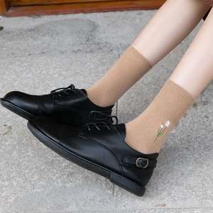 Black lace-up leather loafers with khaki mid-tube socks featuring daisy embroidery