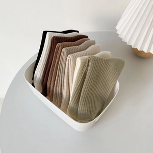 Set of waffle knit crew socks in earth tones displayed in a minimalist white box
