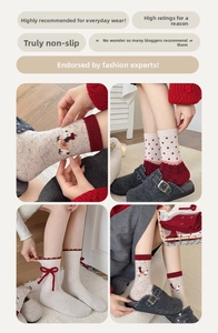 Close-up of red wool socks featuring cute puppy embroidery and decorative bows