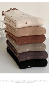 Detail of knit socks with polka dot patterns and delicate brown ruffled trim edges