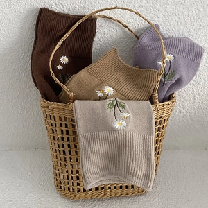 Daisy embroidery cotton crew socks in neutral tones displayed in a woven basket