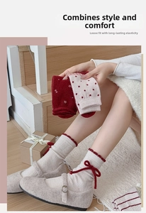 Detailed close-up of warm red wool socks featuring cute bows and festive winter patterns