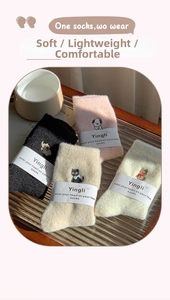Detail von weichen Thermosocken mit Tiermotivstickerei in vier Farben auf Tablett