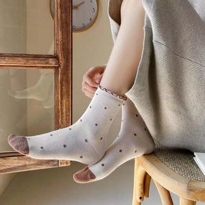Cozy cream cotton crew socks with brown polka dots and ruffled edges for women