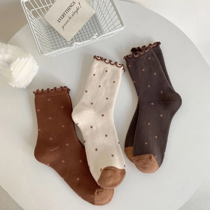 Three pairs of retro polka dot cotton crew socks with ruffled edges in warm autumn tones