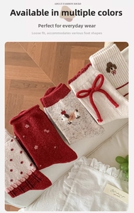 Close-up of red wool socks featuring cute 3D bows and cartoon puppy knit patterns