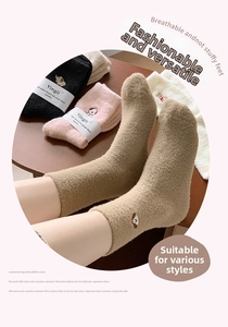 Detail von warmen Flauschsocken mit Tierstickerei und Marken-Papierverpackung