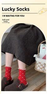 Detail of red crew socks with white floral embroidery and scalloped frill edge trim