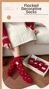 Détail de chaussettes rouges en coton avec motifs cœurs blancs et texture floquée