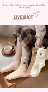 Nahaufnahme dicker Thermo-Wollsocken mit Tierstickerei in gemütlicher Wohnatmosphäre