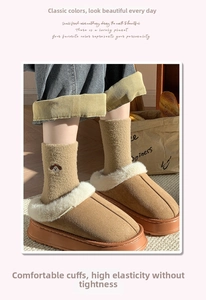 Detail von warmen Wintersocken mit Hundestickerei und Damen-Hausschuhen aus Fleece