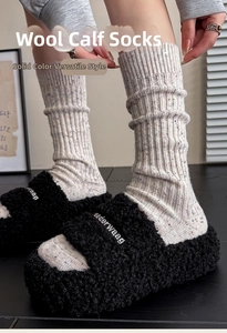 Detail of speckled wool mid-calf socks with vertical ribs paired with plush slippers