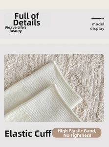 Detailed close-up of white wool knit socks showing elastic cuffs and ribbed texture