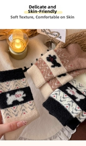 Detail von Fair-Isle-Stricksocken mit süßen Hundemustern und roten Herzdetails für Damen