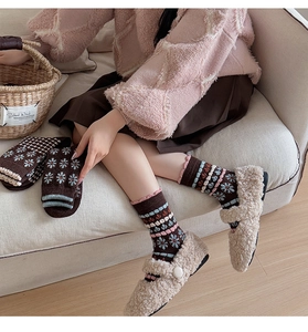 Close-up of vintage brown wool socks with floral patterns and pink ruffle edge trim