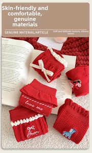 Detail of red knit socks featuring blue pony embroidery, white bows and lace trim