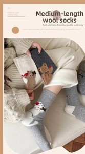 Detail of wool socks featuring cute bear and cat embroidery in warm autumn colors