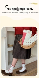 Detail of red floral and plaid cotton socks with bows in a rustic basket