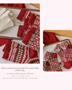 Detail of red jacquard knit wool socks with Fair Isle snowflake patterns and white gloves