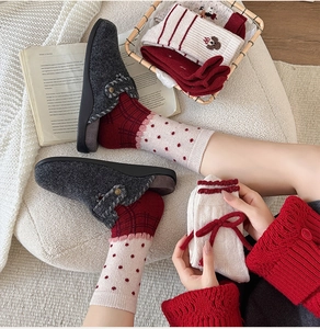 Winter home cozy set with wool socks and grey felt slippers on a knitted blanket