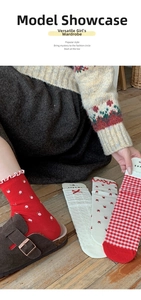 Close-up of red and white floral patterned socks with cute ruffle trims and bow details