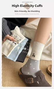 Detailaufnahme der Fair-Isle-Socken mit Bärenstickerei und elastischem Rippstrickbündchen