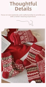 Detail of red wool socks featuring white heart and snowflake Fair Isle knitting patterns
